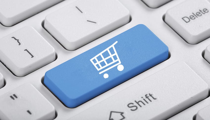 A close-up of a computer keyboard featuring a blue key with a shopping cart icon.
